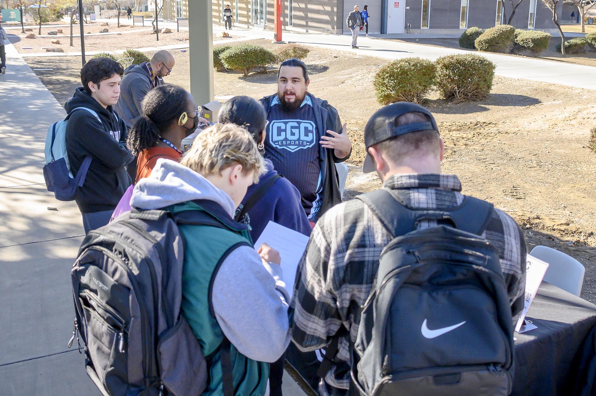 CGCC staff member speaking with students in the campus courtyard and providing college information.