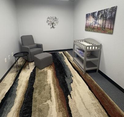 Lactation lounge at the Pecos Campus with a lounge chair, changing station, and wall artwork