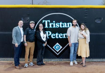 Tristan Peters and others posing next to Tristan's new baseball-diamond shaped dedication plaque.