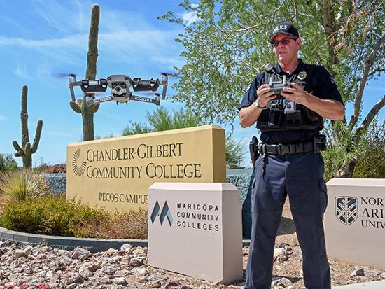 Police flying a drone in front of the CGCC sign.