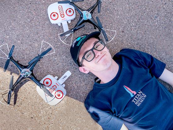 2025 AI Drone & Discovery Summer Camp boy lying on the ground next to the two drones he built.