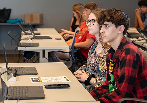 High school students in a classroom listing to a lesson presentation..
