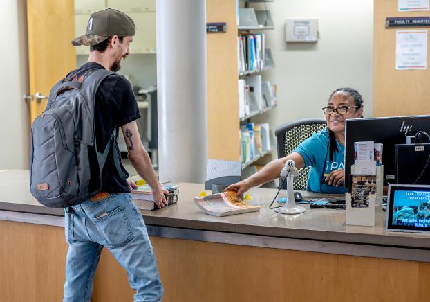 Student speaking with CGCC staff member in an office setting.