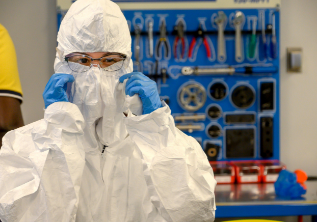 Student participating in a semiconductor technician training program while wearing protective lab equipment.